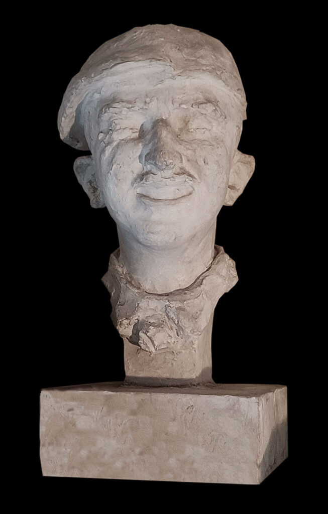 Carved head, self-portrait of Quniton Oliver Jones in his beret.